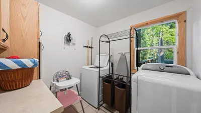 a laundry room with a washing machine and a window at Sweet Pine Deck Hot Tub Cozy Modern Interior Close to Ski Resort in Pomins