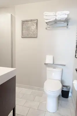 a white bathroom with a toilet and towels at Lakeside hotel room #1 in Kings Beach in Kings Beach