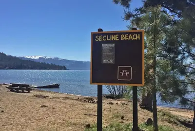 a sign on a beach next to a body of water at Lakeside Hotel room #6 in Kings Beach in Kings Beach