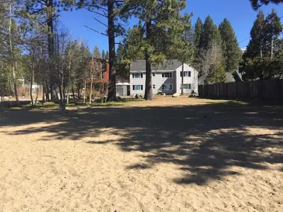 a large yard with a white house and trees at Lakeside Hotel room #7 in Kings Beach in Kings Beach