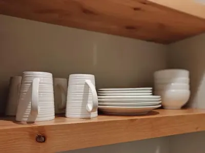 a shelf with white plates and bowls on it at Lakeside Hotel room #7 in Kings Beach in Kings Beach