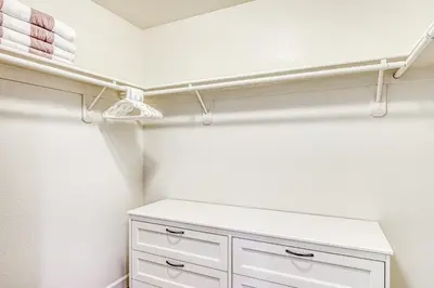 a closet with white cabinets and a shelf at Slide Creek Retreat in Bass Lake