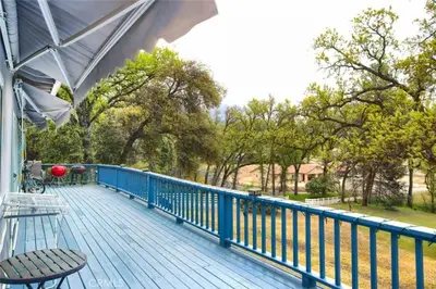 a blue deck with a bench on a porch at Beautiful Pet-Friendly Spacious Lodge near Yosemite & Lakes 12 Beds 6 BR up to 16 people in Oakhurst