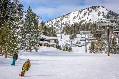 two people standing in the snow on a ski slope at Chamonix 20 in Mammoth Lakes