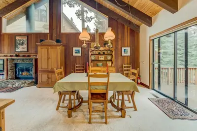 a dining room with a table and chairs and a fireplace at Grizzly Cabin in Truckee