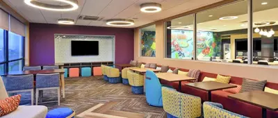 a restaurant with tables and chairs and a tv at Tru By Hilton Manteca in Manteca