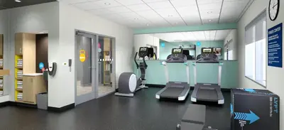 a gym with treadmills and chairs in a room at Tru By Hilton Manteca in Manteca