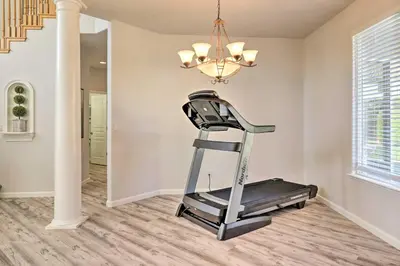 a gym with a treadmill and a chandelier at Family-Friendly Modesto Home with Grill and Yard in Modesto
