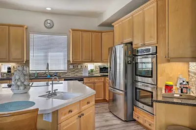 a kitchen with wooden cabinets and a stainless steel refrigerator at Family-Friendly Modesto Home with Grill and Yard in Modesto