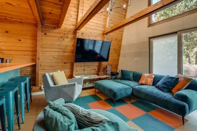 a living room with a couch and a tv at Charming Pinecrest Cabin with Private Deck in Strawberry