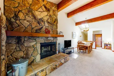 a living room with a stone wall with a fireplace at Tahoe Enchantment in Zephyr Cove