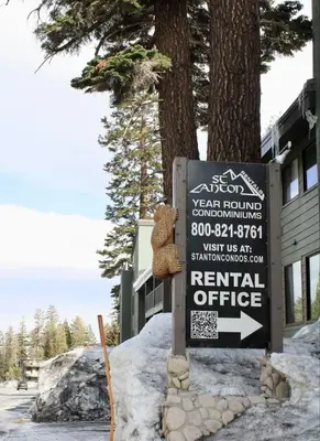 a sign sitting in the snow next to a tree at St Anton Condos #83 condo in Mammoth Lakes