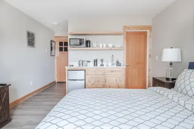 a bedroom with a white bed and a kitchen at Lakeside Hotel room #5 in Kings Beach in Kings Beach