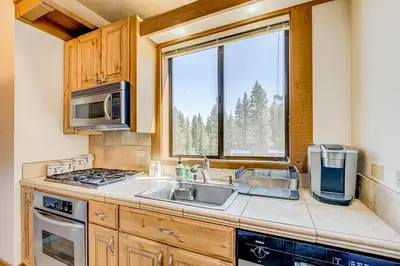a kitchen with a sink and a microwave and a window at Silver Strike Sanctuary in Truckee