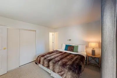 a bedroom with a large bed and a table with a lamp at Falcon Nest in Incline Village