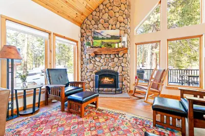 a living room with a stone fireplace in a house at Oso Lodge in Yosemite West
