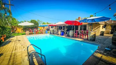 a swimming pool with umbrellas and a restaurant at Tropical Paradise in Fresno