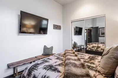 a bedroom with a bed and a tv on the wall at Great Views Fully Renovated Luxury 4 Bedroom 3 Full Bathrooms and Half Bath Snowcreek 732 Phase V in Mammoth Lakes
