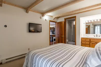 a bedroom with a bed and a tv on the wall at Walk to Lift Updated 2 Bedroom 2 and a Half Bathrooms 1849 Condos 209 Steps to Canyon Lodge Sleeps 6 in Mammoth Lakes