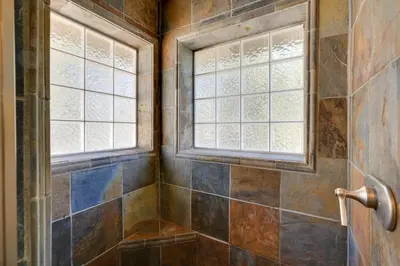 a bathroom with a shower with two windows at Colfax Getaway with Hot Tub, Mountain Views! in Colfax