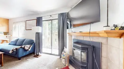 a living room with a fireplace and a blue couch at La Vista Blanc #59 condo in Mammoth Lakes