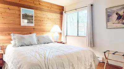 a bedroom with a bed with a wooden wall at Snowflower #87 condo in Mammoth Lakes
