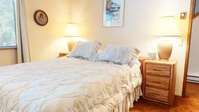 a bedroom with a large bed and two lamps at Snowflower #87 condo in Mammoth Lakes