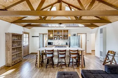 a kitchen with wooden ceilings and a table with stools at Cascadel Hideaway in North Fork
