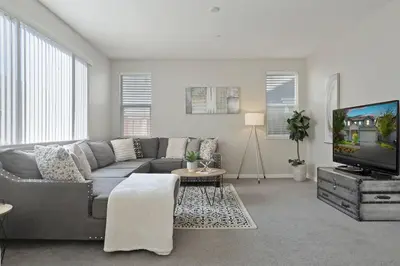 a living room with a gray couch and a tv at Stunning River Islands Home Near Lake & Boat House in Lathrop