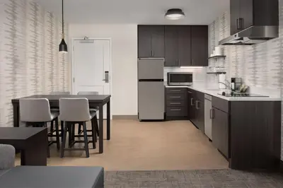 a kitchen with a table and a white refrigerator at Residence Inn by Marriott Fresno Clovis in Clovis