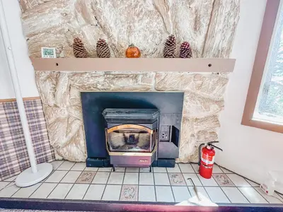 a stone fireplace with a stove in a room at Perfect Ski Rental 2 blocks from Village Gondola in Mammoth Lakes