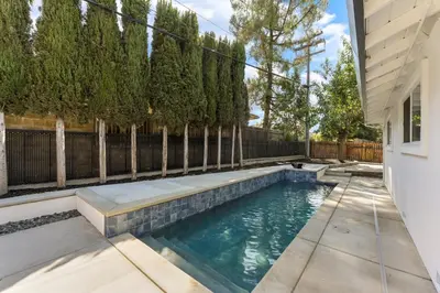 a swimming pool in the backyard of a house at Fully Renovated 4 Bedroom Home with Pool! in Roseville