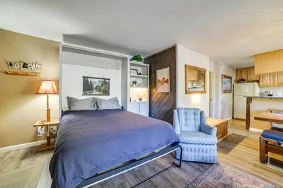 a bedroom with a bed and a blue chair at Cozy Mammoth Lakes Studio 5 Mi to Ski Slopes in Mammoth Lakes