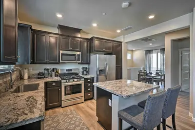 a kitchen with wooden cabinets and a counter top at Pet-Friendly Elk Grove Retreat with Balcony! in Elk Grove