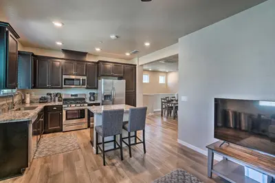 a kitchen with wooden cabinets and a table and chairs at Pet-Friendly Elk Grove Retreat with Balcony! in Elk Grove
