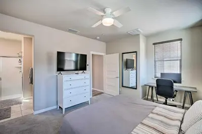 a bedroom with a dresser with a television and a desk at Pet-Friendly Elk Grove Retreat with Balcony! in Elk Grove