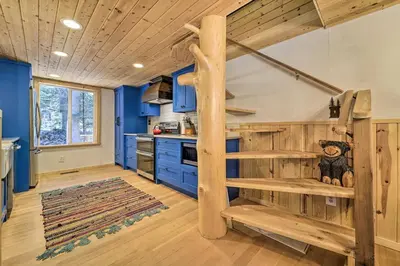 a log cabin kitchen with blue walls and wooden stairs at Waterfront Echo Lake Cabin with Deck, Mtn Views in Twin Bridges