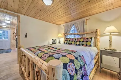 a bedroom with a wooden bed in a room at Waterfront Echo Lake Cabin with Deck, Mtn Views in Twin Bridges