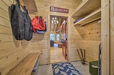 a cabin hallway with wood paneling and a door with bags at Waterfront Echo Lake Cabin with Deck, Mtn Views in Twin Bridges