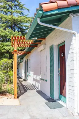 a white building with an orange roof and a door at The Bonnie Inn Unit 6 in San Andreas