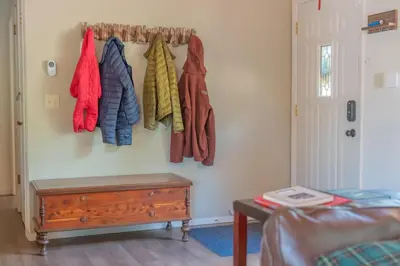 a room with a rack of coats and a bed at Sweet Arnold Cabin in Arnold