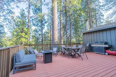 a deck with chairs and a table and a grill at Sweet Arnold Cabin in Arnold