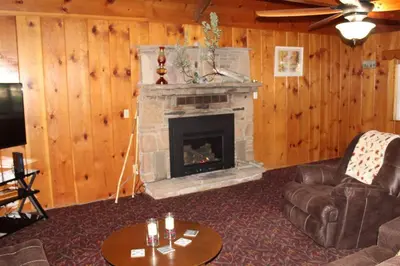 a living room with a fireplace in a house at Rustic Chapparal Cabin at Bass Lake Heights in Oakhurst
