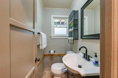 a bathroom with a sink and a toilet and a mirror at Rustic Oakhurst Retreat Less Than 4 Mi to Bass Lake! in Oakhurst