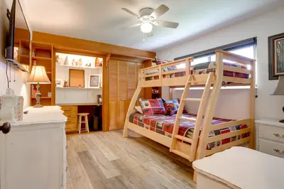 a bedroom with two bunk beds and a desk at 1 Mi to Lake Hot Tub Haven in Pollock Pines! in Pollock Pines
