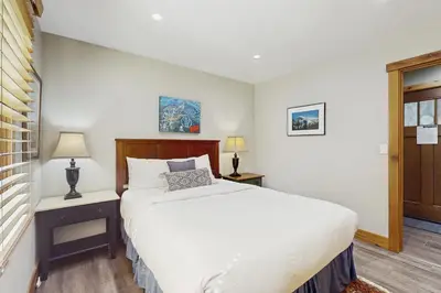 a bedroom with a white bed and two night stands at Coyote Fork Escape in Truckee