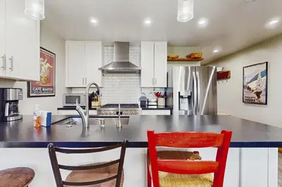 a kitchen with a counter with two chairs and a refrigerator at Coyote Fork Escape in Truckee