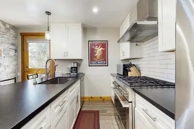 a kitchen with white cabinets and black counter tops at Coyote Fork Escape in Truckee