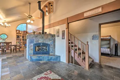 a living room with a fireplace and a staircase at Deck and Grill Mtn Haven in Stanislaus Natl Forest in Arnold