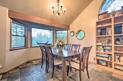 a dining room with a wooden table and chairs at Deck and Grill Mtn Haven in Stanislaus Natl Forest in Arnold